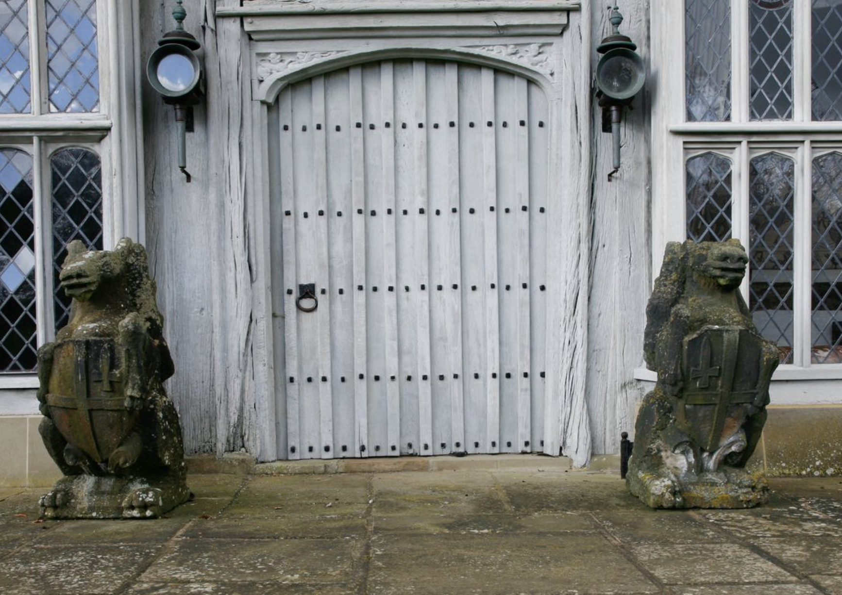 A pair of carved stone armorial griffins